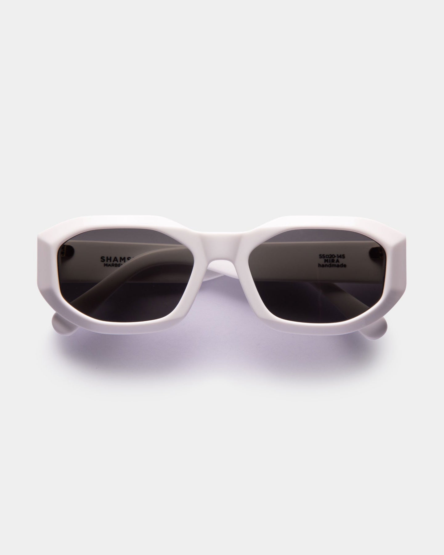 A pair of white, oversized sunglasses with a bold, fashionable design.