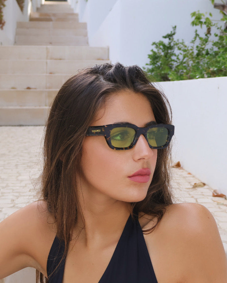 Woman wearing sunglasses with a white architectural background