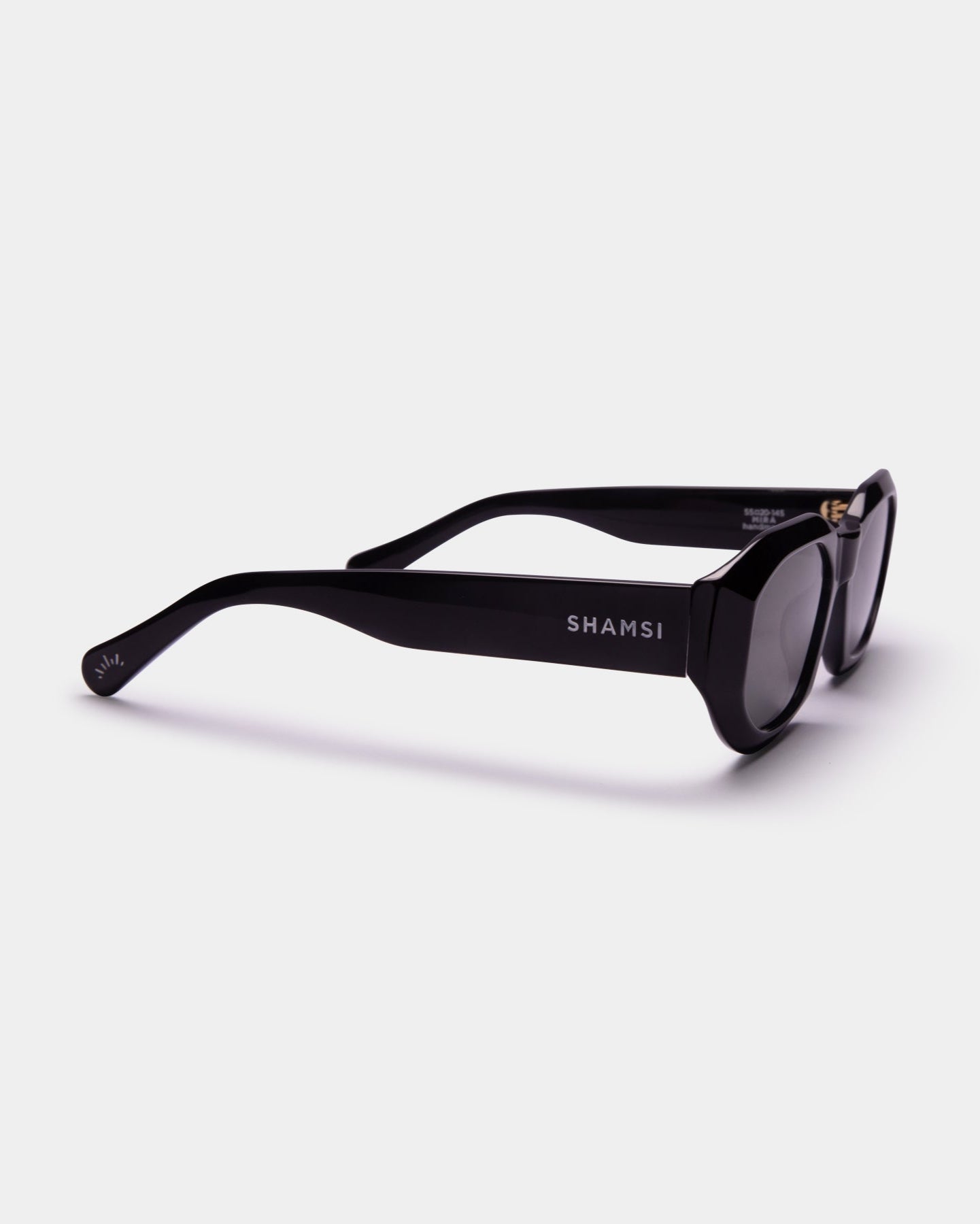 Black sunglasses with 'SHAMSI' branding on a white background