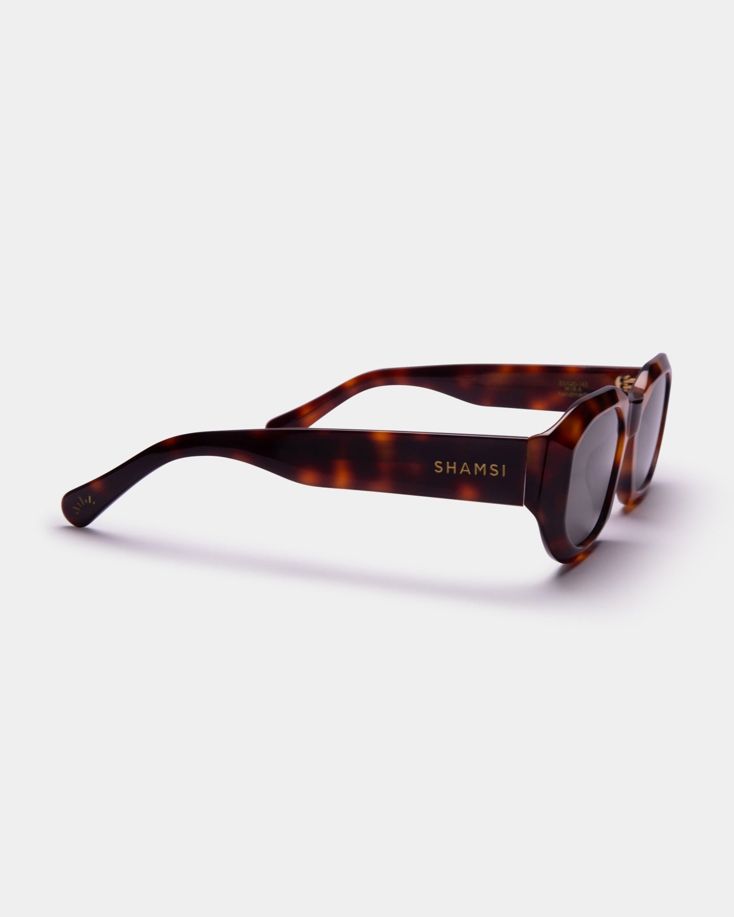 Sunglasses with tortoiseshell frame and 'SHAMSI' branding on a white background