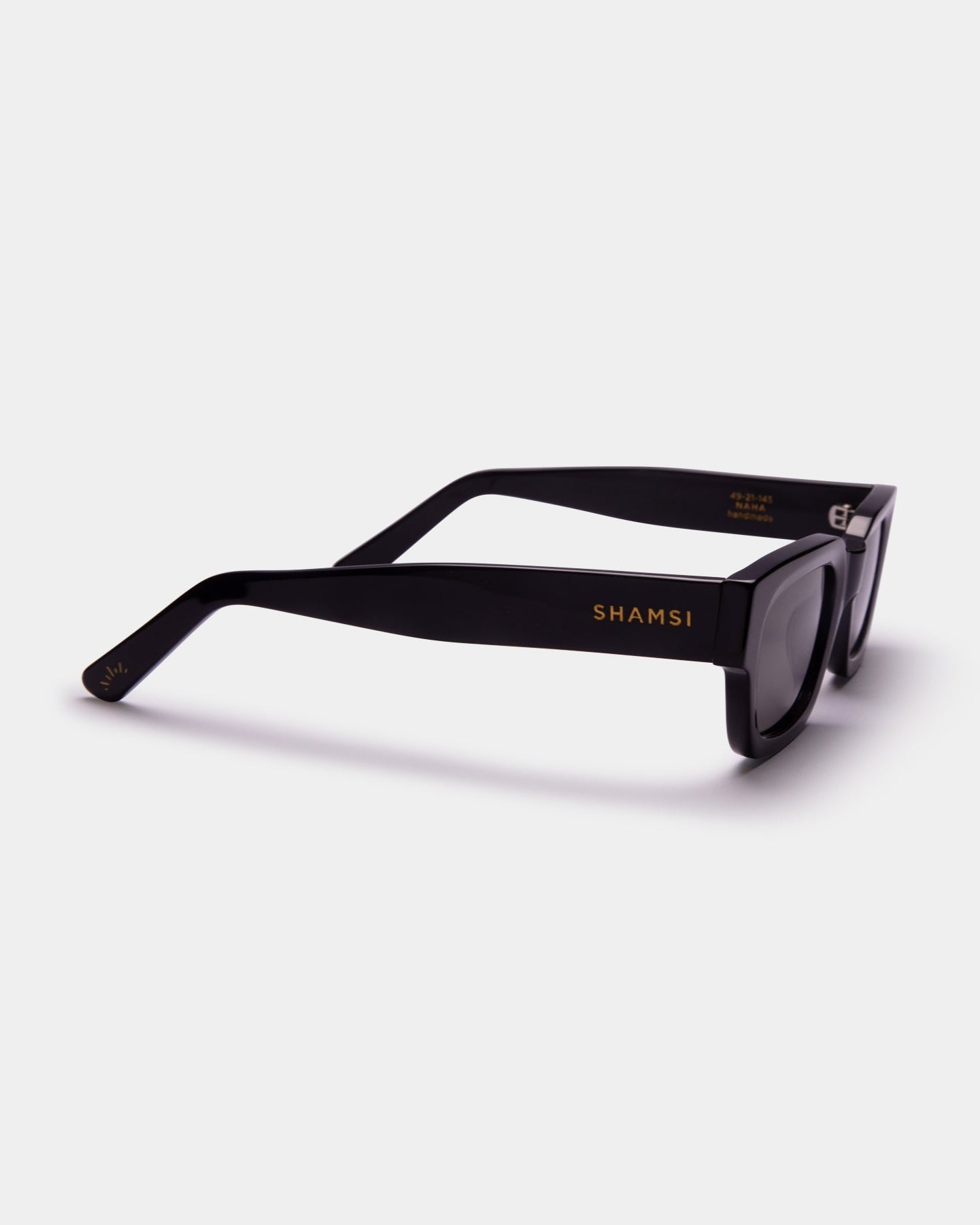Black sunglasses with 'SHAMSI' branding on a white background