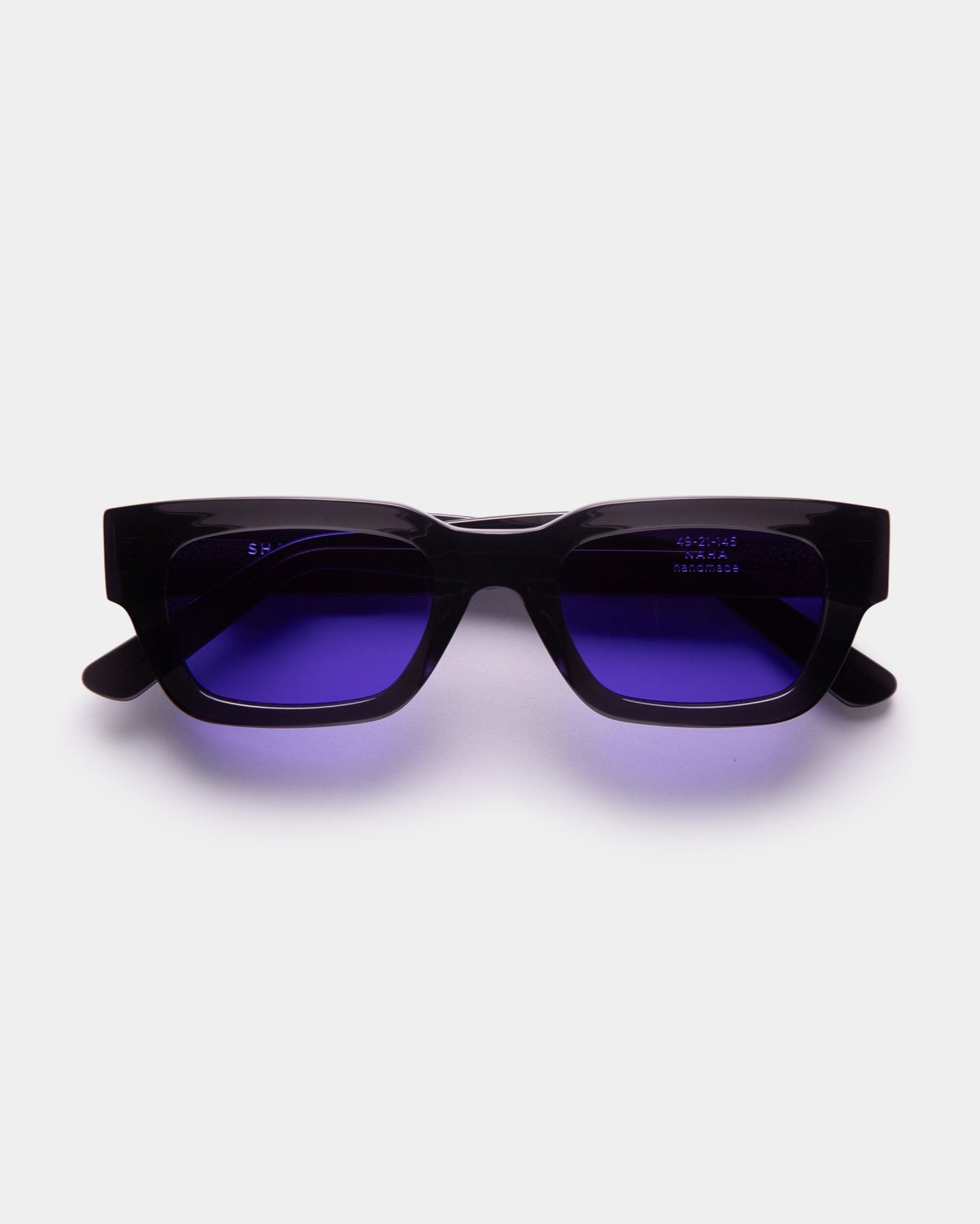 Black sunglasses with purple lenses on a white background