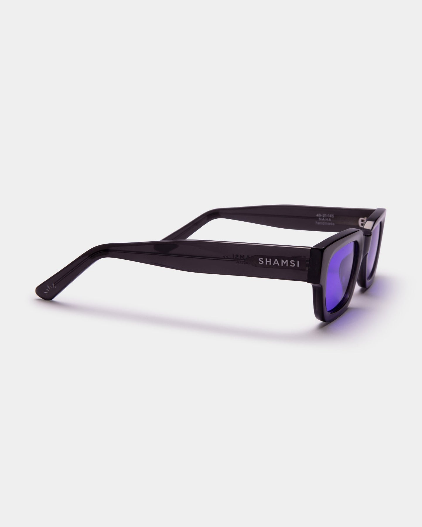 Black sunglasses with purple lenses on a white background