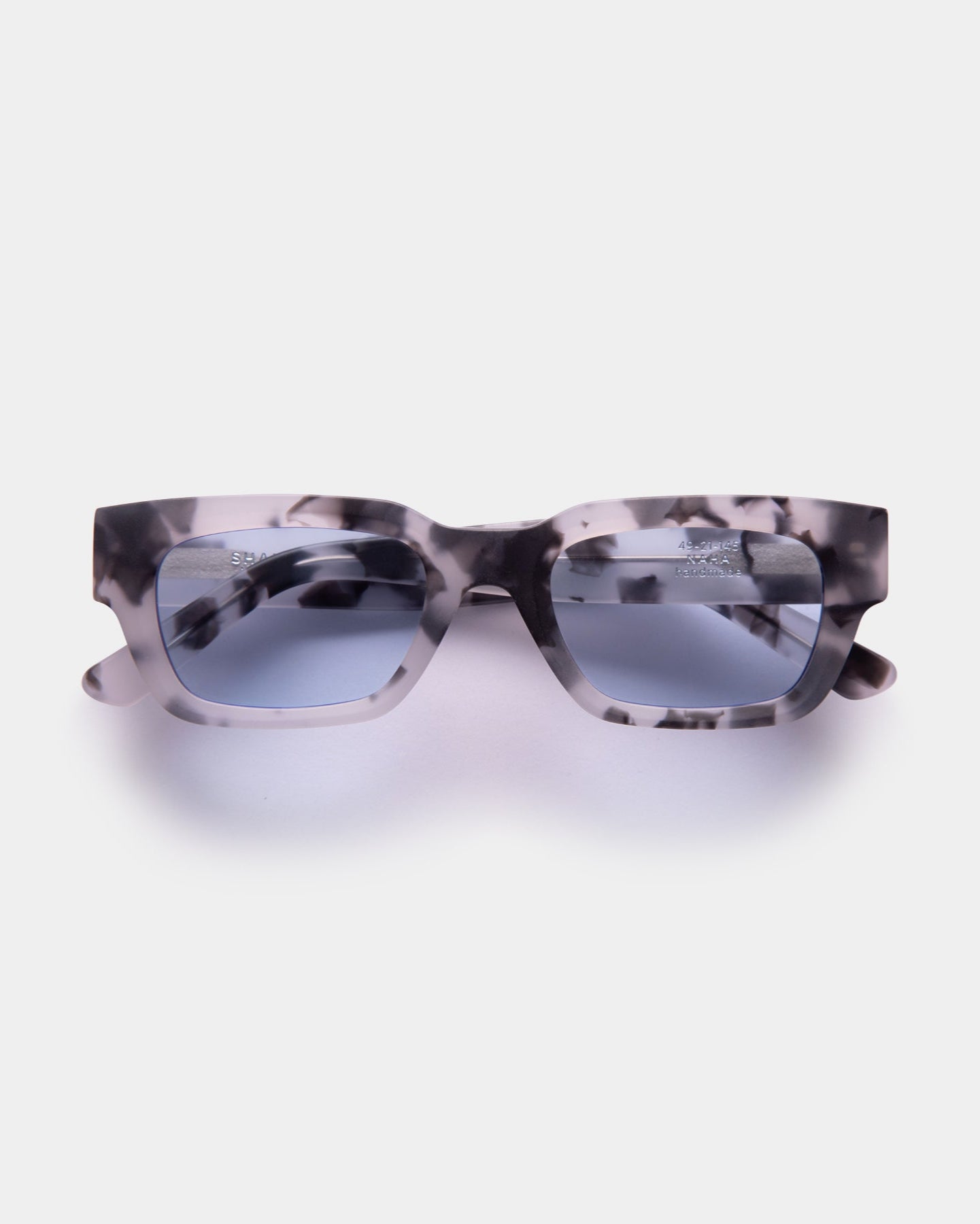Sunglasses with tortoiseshell frame and blue lenses on a white background