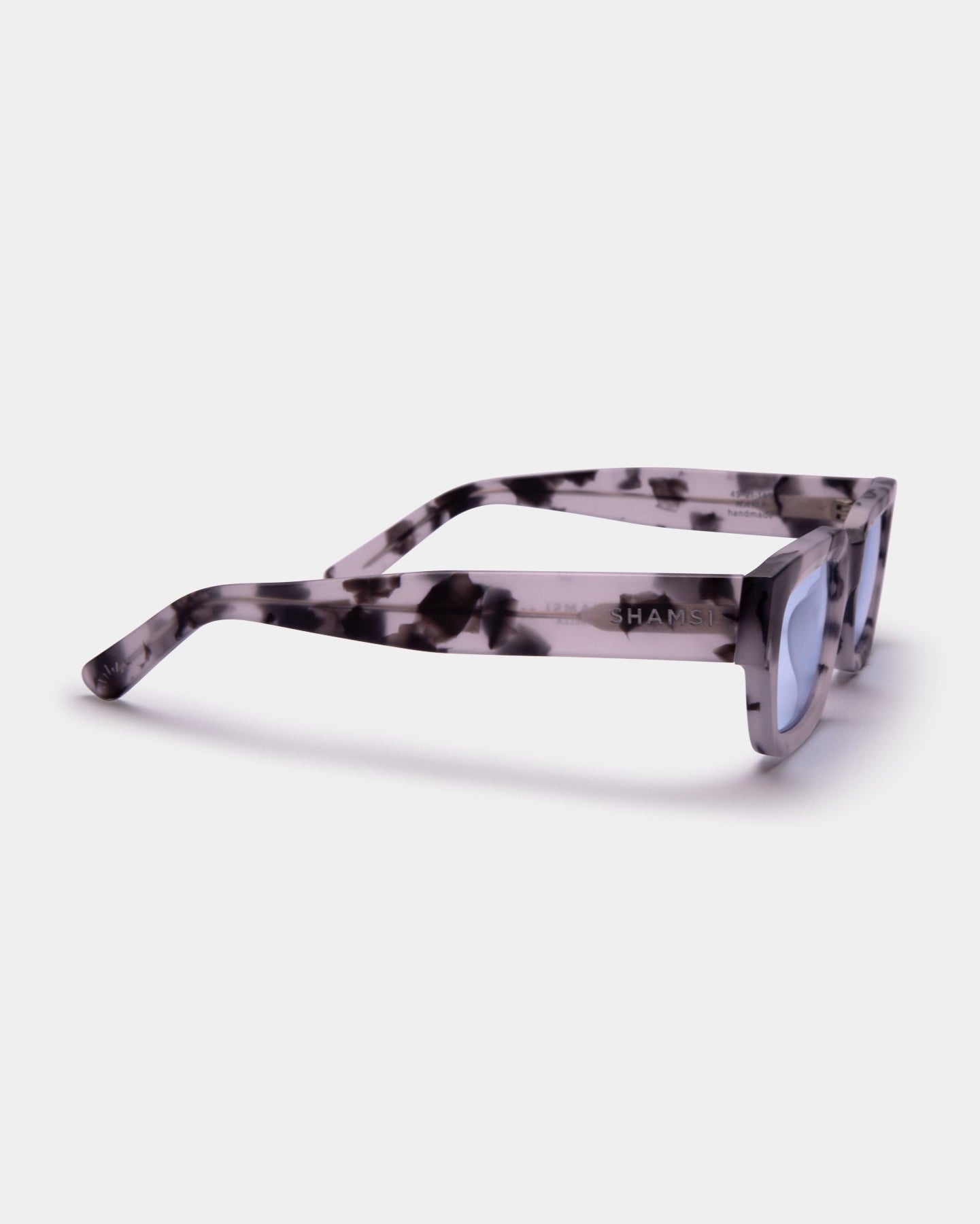Sunglasses with a tortoiseshell pattern on a white background