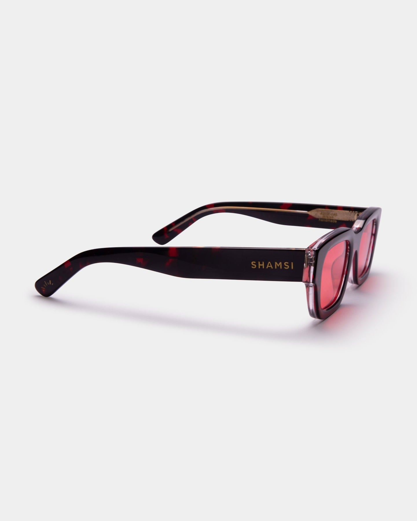 Sunglasses with tortoiseshell frame and pink lenses on a white background