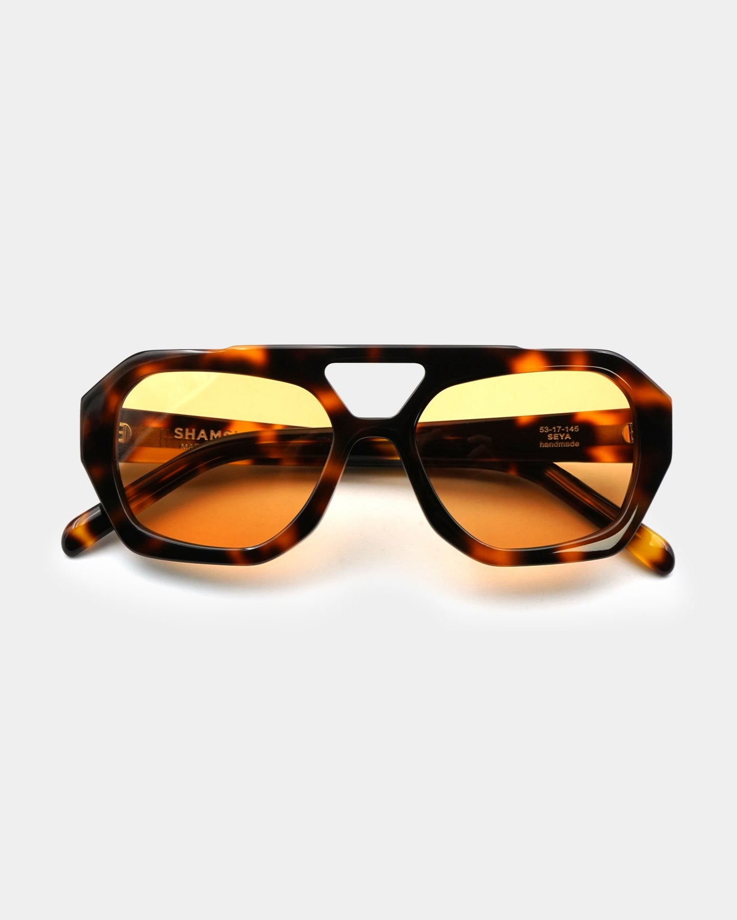 A pair of SEYA sunglasses with a tortoiseshell patterned frame and amber-colored lenses.