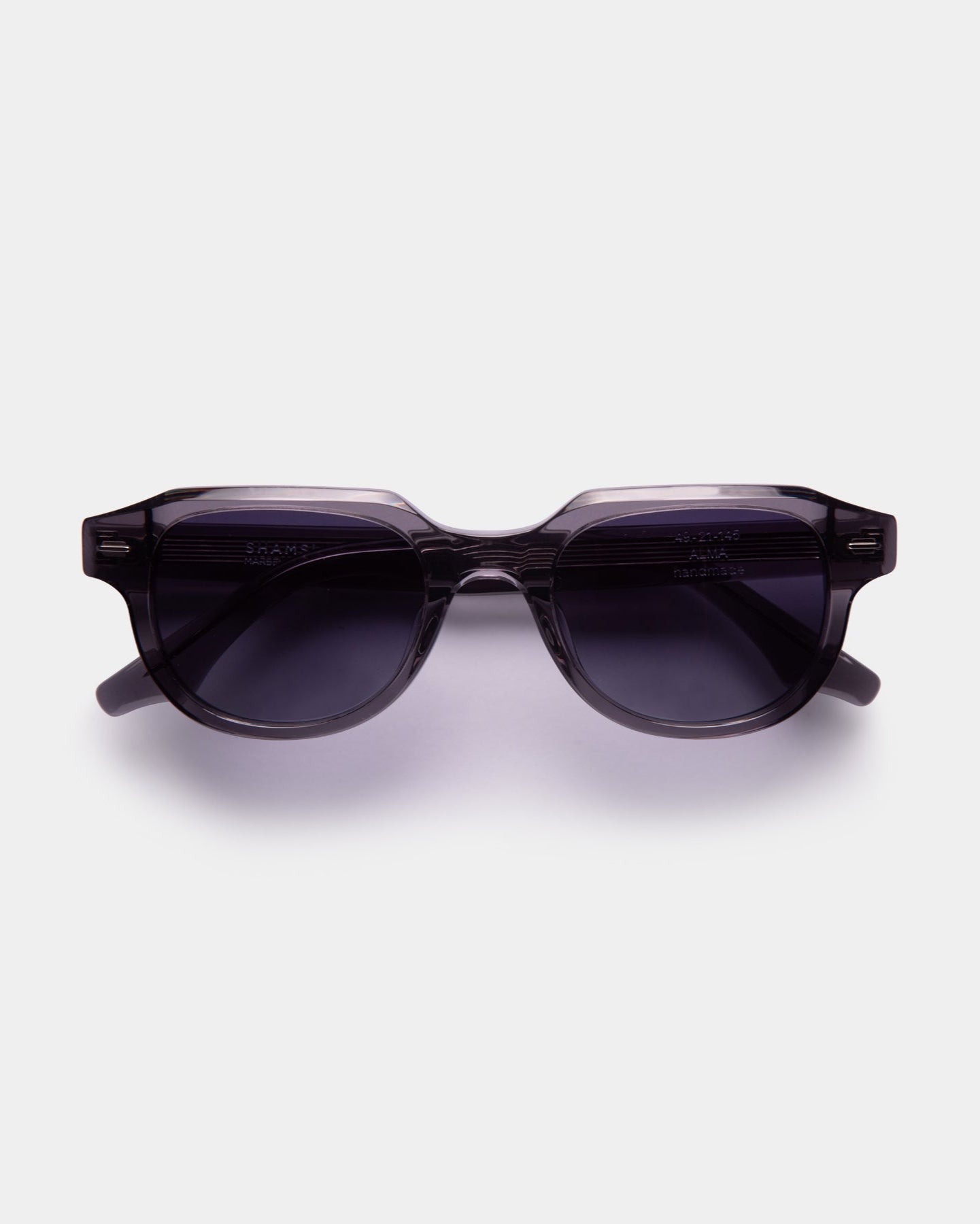 A pair of black ALMA sunglasses with a slightly rounded silhouette, displayed against a white background.