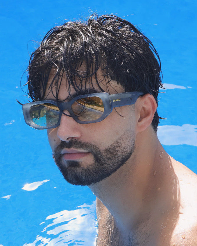 Man with sunglasses and wet hair in a pool