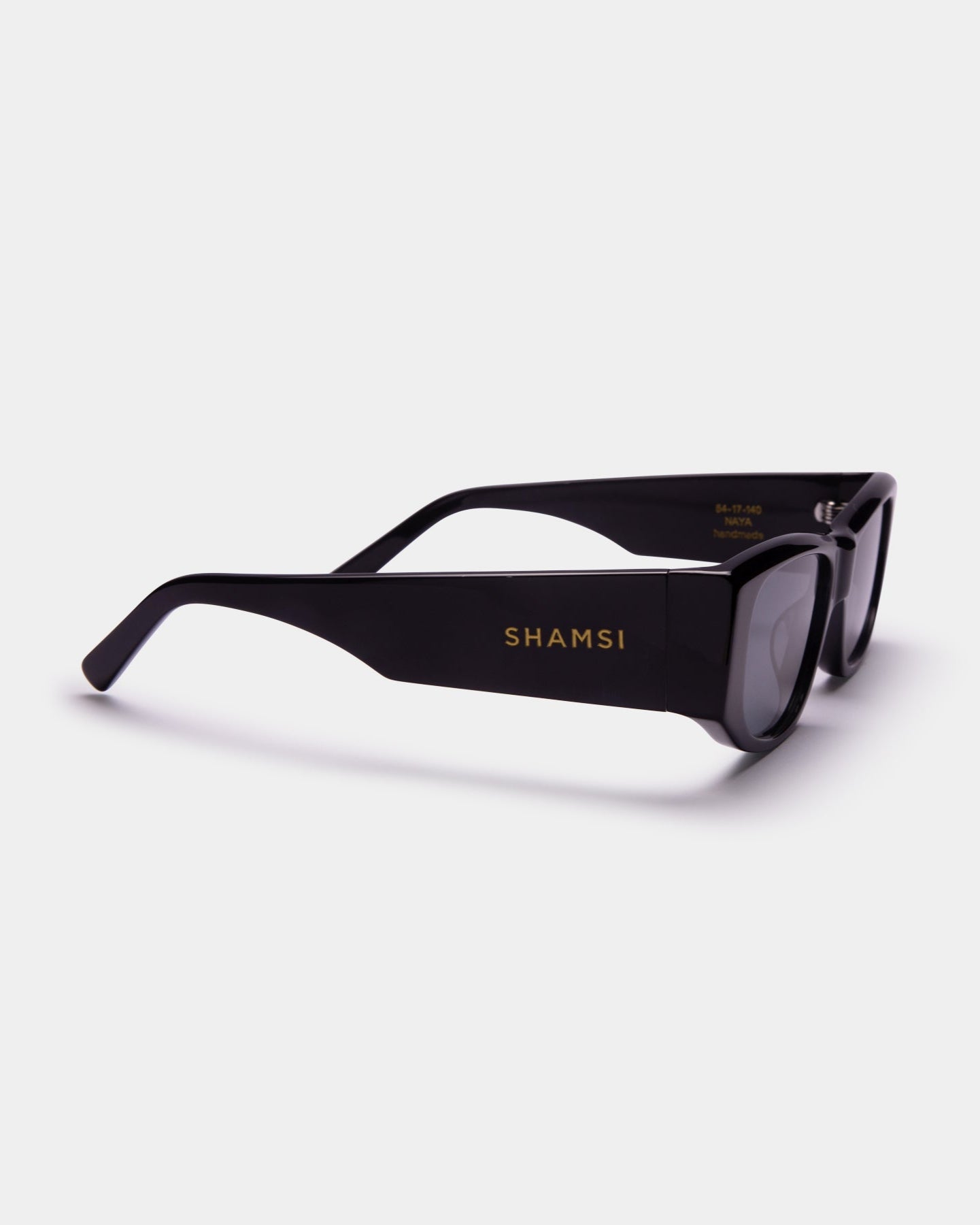 Black sunglasses with 'SHAMSI' branding on a white background
