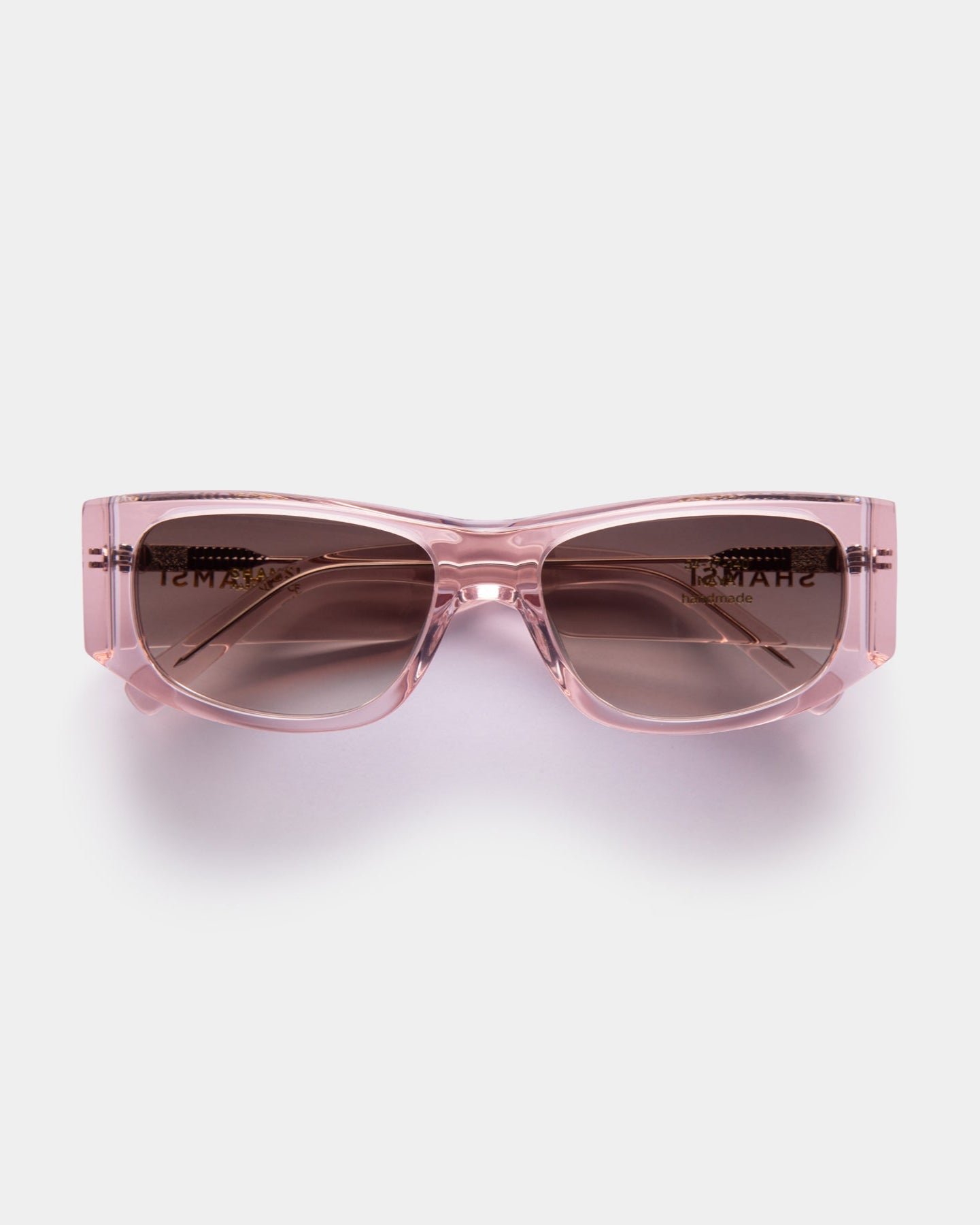 Pink sunglasses with a clear frame on a white background
