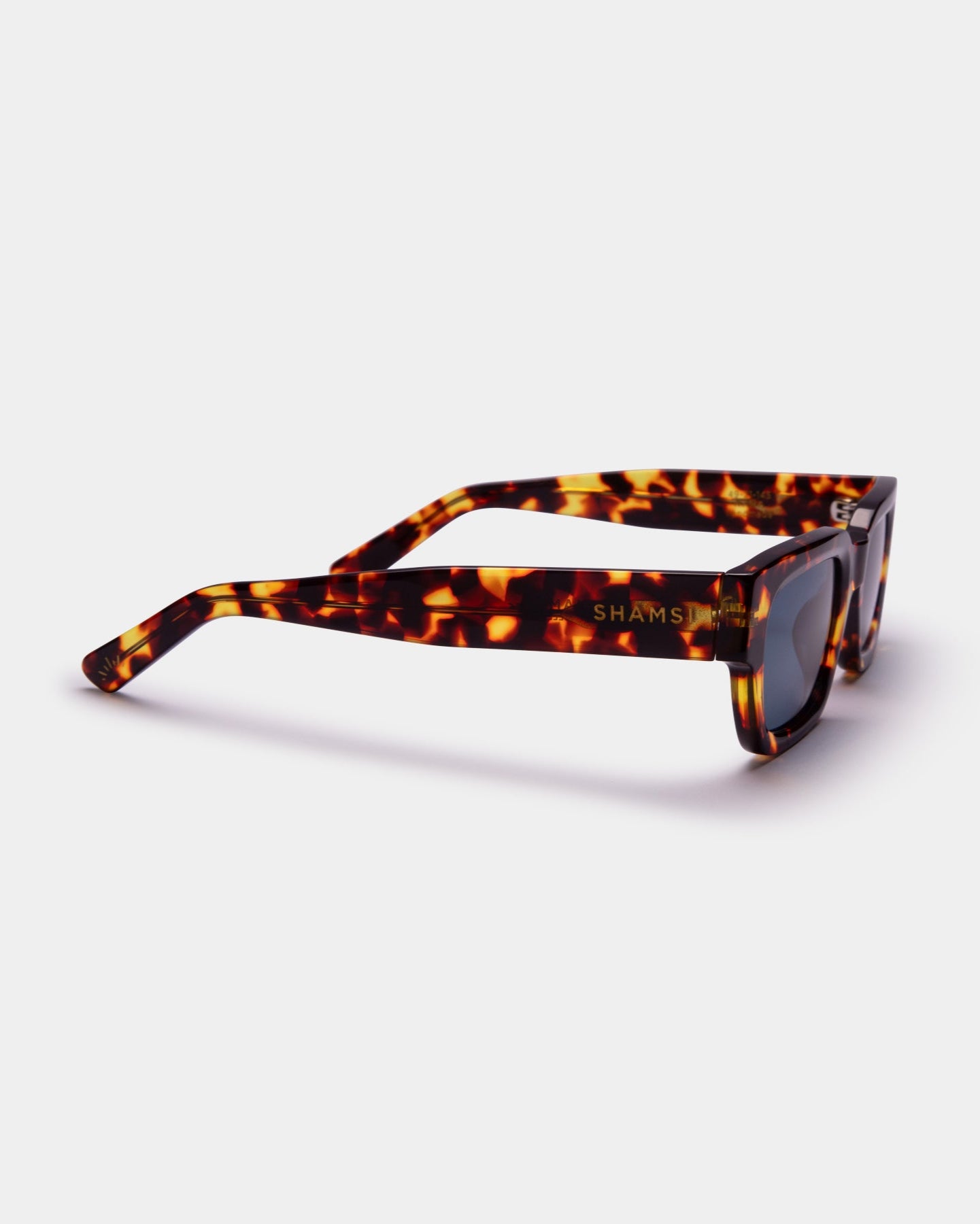 Sunglasses with tortoiseshell frame and dark lenses on a white background